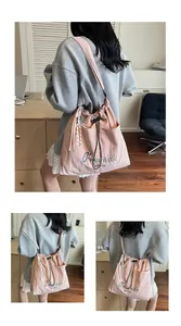 Detailansicht der rosa Kordelzugtasche mit blauer Stickerei und zweifarbigem Band