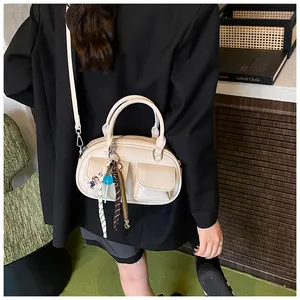 Off-white crossbody bowling bag shown in use with decorative charms and pockets