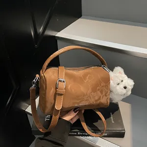 Bolso Boston marrón con textura de mármol y colgante de perro de peluche