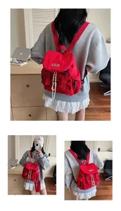 Trois vues d'un sac à dos d'école en nylon rouge avec cordon de serrage et boucle à rabat