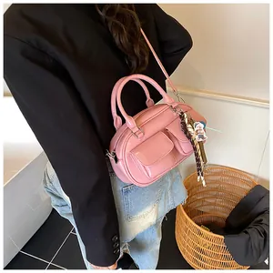 Pink glossy leather Boston bag with dual front pockets and decorative scarf detail