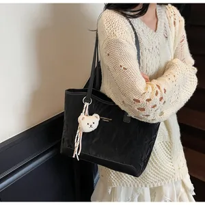 Schicke schwarze Shopper Tasche mit Knitteroptik und weißem Plüschbär-Anhänger Detail