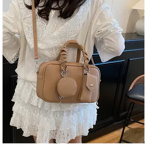 Dettaglio borsa Boston 3-in-1 in pelle marrone con manico intrecciato e mini bustine