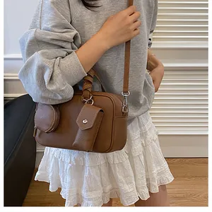 Borsa bowling marrone con manici intrecciati e tasche accessorie indossata dalla modella