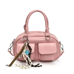 Pink trendy bowling bag with double outer pockets and playful bag charms for women