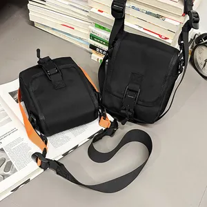 Minimalistische schwarze Nylon-Umhängetasche mit Schnallenverschluss auf Büchern