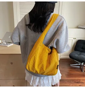 Rear view of a model wearing a large bright yellow nylon tote bag for daily commute
