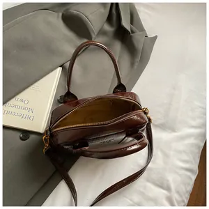 Sac bowling en cuir brillant marron foncé avec deux poignées et bandoulière réglable