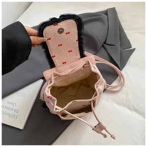 Détail du sac à dos rose à motifs nœuds montrant le cordon et le bord en dentelle