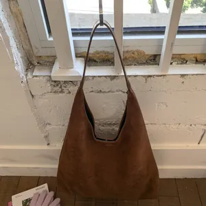 Detail view of large brown suede hobo bag showing soft texture and spacious commuter design