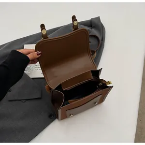 Detailed interior of caramel brown faux leather bag with main compartment and zipper pocket