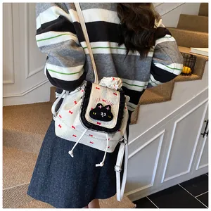 Détail d'un sac à dos blanc avec motif nœuds rouges et applique chat noir mignon