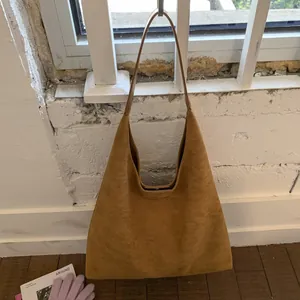 Detailed view of ginger suede tote bag with magnetic closure and slim shoulder strap