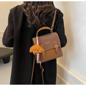 Detail of vintage patchwork leather crossbody bag with cute puppy plush charm on model