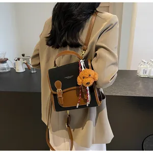 Close-up of vintage black and brown leather backpack with decorative buckle and dog charm
