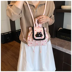 Détail du mini sac à dos rose avec applique chat, dentelle et imprimé nœuds