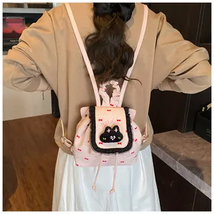 Sac à dos rose pour étudiante avec chat noir et nœuds rouges porté par un mannequin