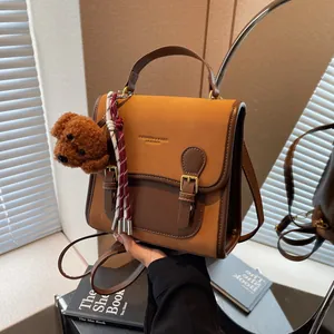 Retro patchwork faux leather shoulder bag in brown with stylish tassel and teddy bear charm