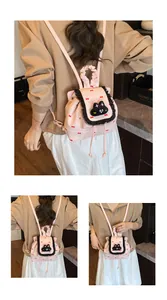Détail du mini sac à dos rose avec motifs de nœuds rouges et bordure en dentelle noire