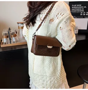 Detail of coffee brown crossbody bag featuring woven texture flap and metallic magnetic clasp