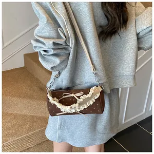 Detalle de un bolso cilíndrico vintage de lunares con encaje y lazo decorativo