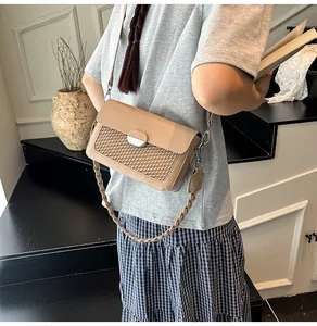 Detail of khaki crossbody bag featuring woven texture and silver metal buckle closure