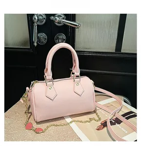 Detail view of pink Boston bag with lychee texture leather and gold hardware