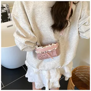 Detalle de bolso bandolera rosa con lunares, encaje y un lazo rosa delicado