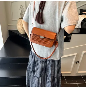Close-up of caramel crossbody bag with woven texture detail and silver buckle