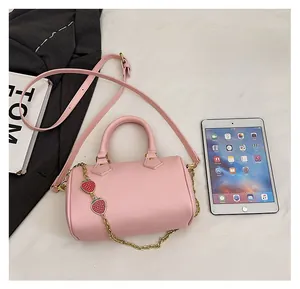 Pink lychee texture Boston bag with strawberry charm compared to iPad mini size