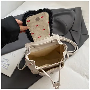Mini sac à dos blanc en cuir avec nœud rouge et bordure en dentelle, vue de l'intérieur
