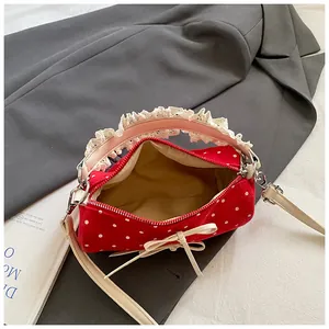 Bolso cilíndrico rojo de lunares con asa de encaje y detalle de lazo elegante