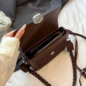 Minimalist brown crossbody bag with woven texture and dual straps in high-angle view