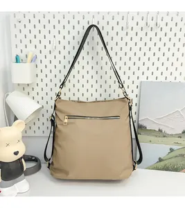 Detailed close-up of khaki tote bag featuring gold zippers and premium elephant texture