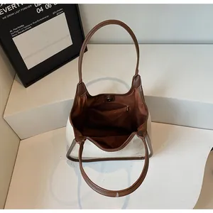 Détails de l'intérieur du sac cabas beige avec bordure en cuir brun et fermoir aimant