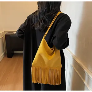 Vista detallada de la espalda de un bolso de hombro de ante amarillo con flecos largos