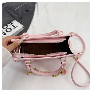 Détails de la capacité intérieure et cuir rose clair à texture litchi du sac à main