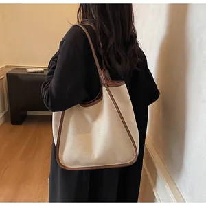 Détail d'un grand sac fourre-tout en toile avec bordure en cuir marron et bandoulière
