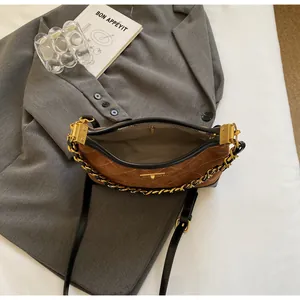 Top view of brown quilted suede bag with gold chain and interior zipper pocket detail
