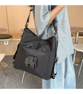 Side view of black nylon tote bag with rhinestone elephant on a crossbody strap