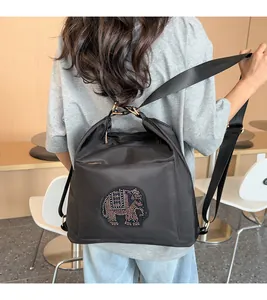 Fashionable black backpack featuring a colorful rhinestone elephant on smooth nylon fabric