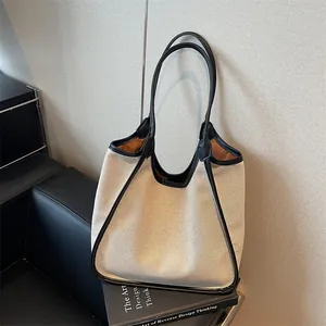 Sac cabas minimaliste en toile blanc cassé avec passepoil en cuir noir et bandoulière