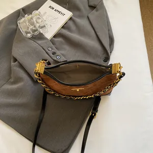 Brown suede hobo bag with quilted stitching and vintage gold chain strap detail