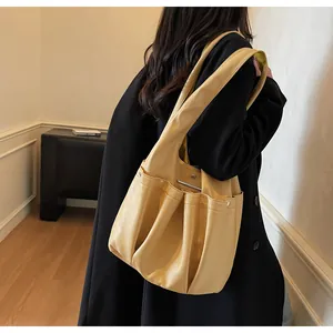 Detailed view of cream leather hobo bag with pleated texture and side pockets