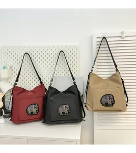 Detail showing various colors of hobo bags with sparkling elephant embroidery and wide strap
