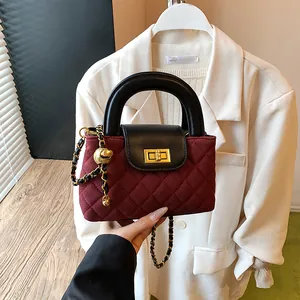Chic burgundy quilted handbag with black leather handle and golden chain strap