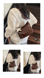 Detail of dark brown patent leather shoulder bag with a metallic silver star charm