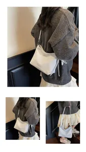 Detail view of cream crescent shoulder bag with silver star charm and matte texture
