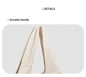 Detail view of the durable cream shoulder strap and high-quality stitching on the tote bag