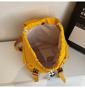Top view of spacious interior with drawstring closure and magnetic buckle on yellow backpack
